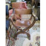A Spanish style carved crossframe chair, with leather slung back and seat