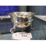 A silver sugar bowl on three pad feet