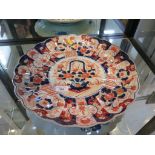 A Japanese scalloped charger in Imari colours, depicting a basket of flowers within a floral