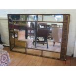 A Regency style giltwood wall mirror, with rosette, tongue and foliate frieze over a segmented