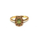 An 18 carat gold cluster ring set with seed pearls and possibly peridot