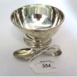 A silver sugar bowl and spoon