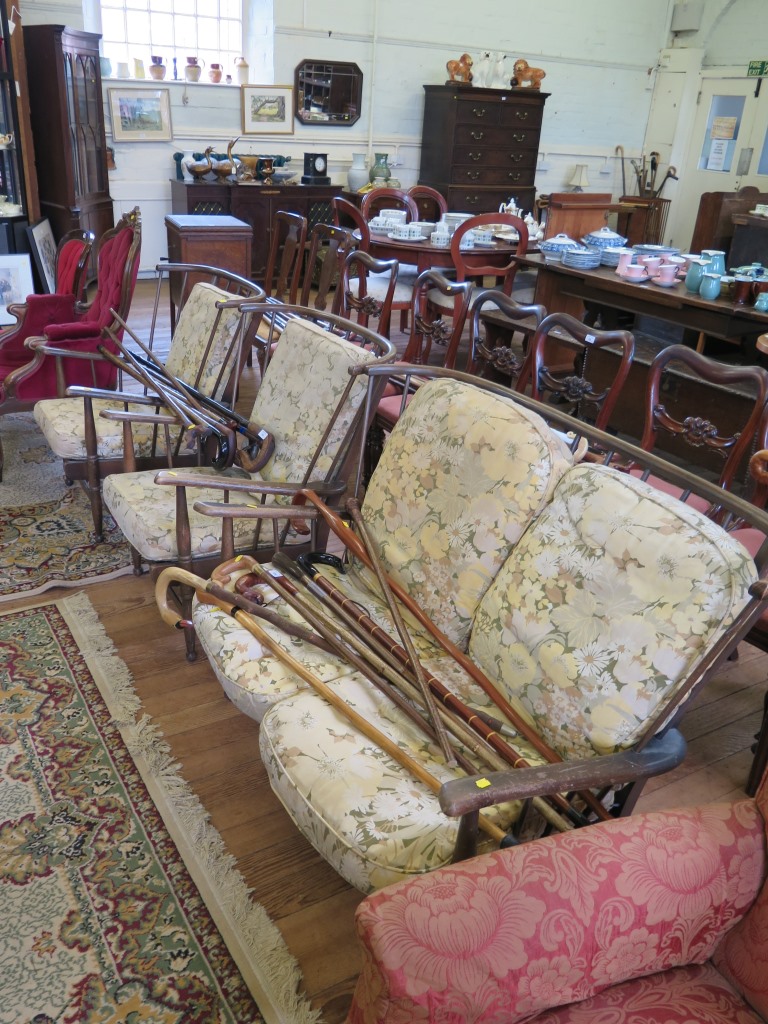 A three piece Ercol style spindle back lounge suite, on turned legs, comprising two seat settee