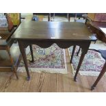 A George III oak side table, the top with indented corners over a deep fret carved frieze, on turned