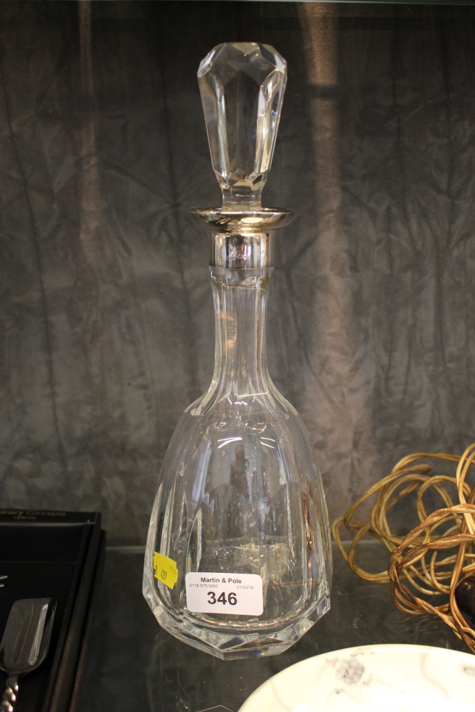 A continental metal collared cut glass decanter of facetted form 30.5cm high