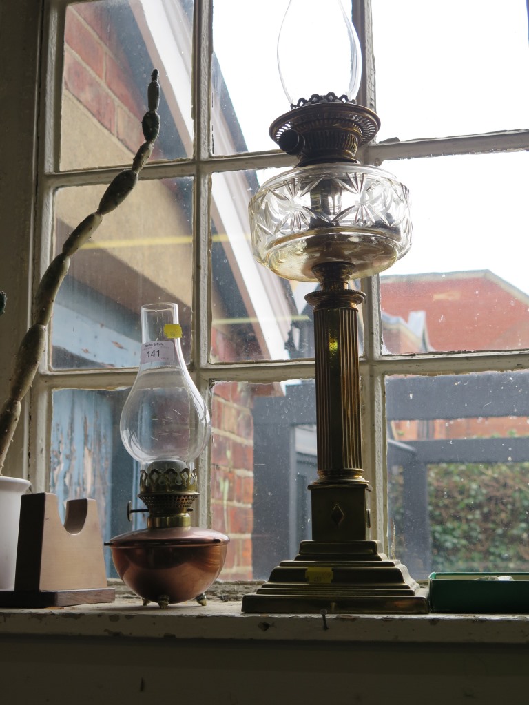 A brass column oil lamp with glass reservoir and a copper oil lamp (2)
