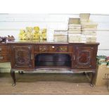 A 1920s mahogany sideboard by Maple & Co, the central drawer and open shelf flanked by foliate