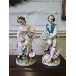 A pair of Staffordshire figures of a couple holding baskets of flowers, 32cm high