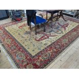 An Afghan carpet, the red and blue medallion on a sand field with floral scrolls within a red