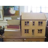 A plywood doll's house, 69cm x 70cm, with loose furnishings, wallpaper, etc, and a model shop front