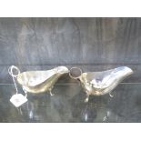 A pair of silver sauce boats of plain form on three pad feet, Sheffield 1933