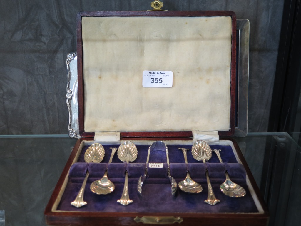 A cased set of six silver teaspoons with shell bowls together with matching sugar tongs