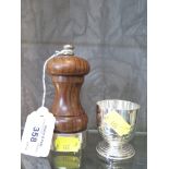 A wood and silver pepper mill and a white metal egg cup