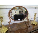 An early 19th century oval dressing table mirror in a serpentine skeleton frame, 50cm wide