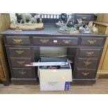 An Edwardian ebonised desk, the leather inset top with raised back of drawers over three frieze