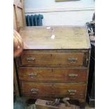 An oak bureau, the sloping fall enclosing a fitted interior over three long graduated drawers and