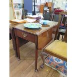 A George III style mahogany Pembroke table, the rounded leaves over a frieze drawer on turned legs