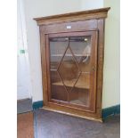 An oak hanging corner cupboard with glazed door, 99cm high, 73cm wide