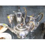 A silver plated tea pot together with another tea pot and matching plated water jug