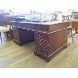 A reproduction mahogany desk, the leather top over three frieze drawers on pedestals each with three