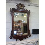 A George III style fret carved mahogany wall mirror, with pierced bird motif over a rectangular