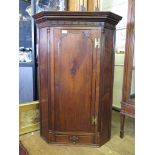 A George III mahogany corner cabinet, the moulded cornice with blind fret carved frieze over
