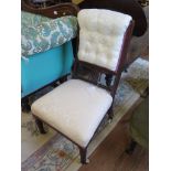 An Edwardian walnut fireside chair, with button upholstered and spindle back, stuffover seat and