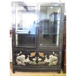 An Oriental black lacquered display cabinet, the twin glazed doors over a pair of doors depicting