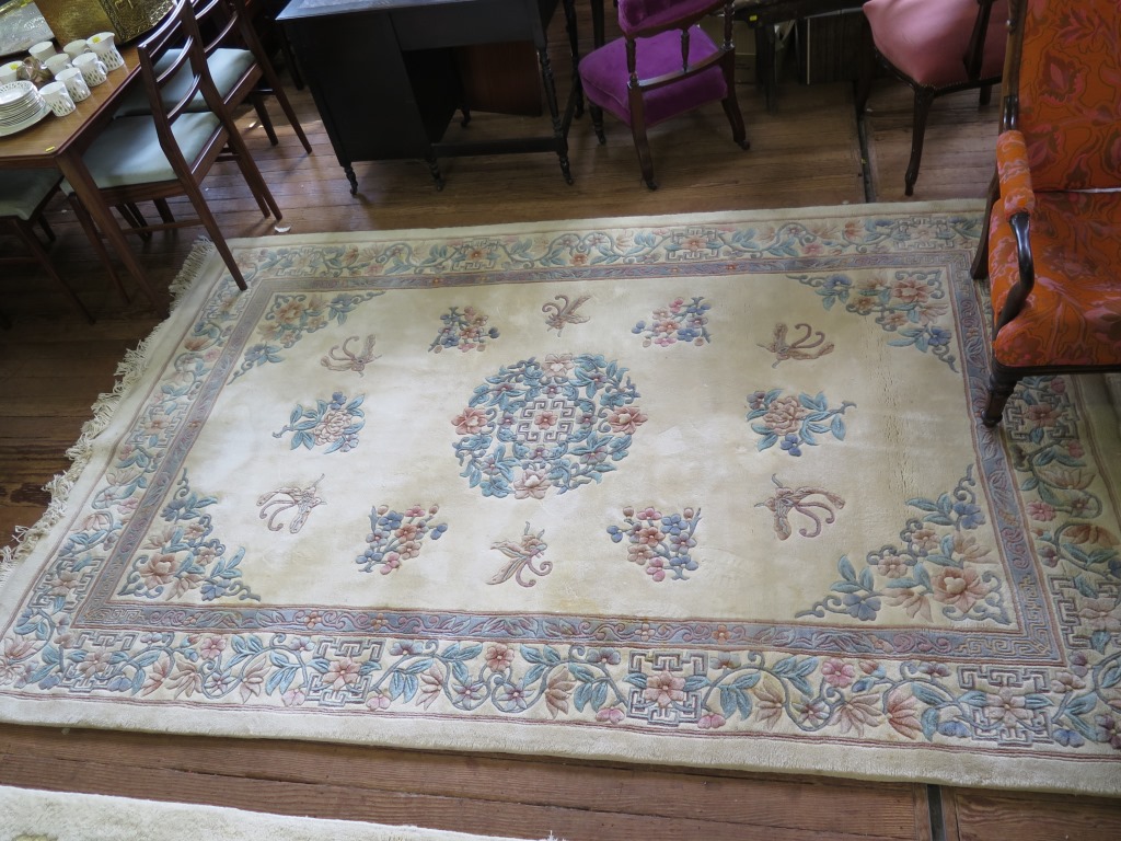 A Chinese wool carpet, the ivory ground with floral sprays within a floral scroll border 306cm x