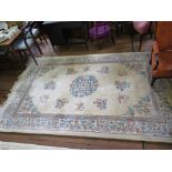 A Chinese wool carpet, the ivory ground with floral sprays within a floral scroll border 306cm x