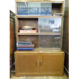 An oak Minty stacking bookcase, with three tiers of shelves with sliding glass doors above a pair of