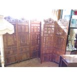 An Indian carved hardwood six fold screen, profusely carved with scrolling leaf motif, each panel,