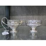 A silver cream jug decorated in relief with pierced gallery and a matching sugar bowl, London 1895