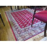 A Kashmir Bokhara style rug, the rows of guls on a red field within a multiple border 244cm x 155cm