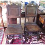 A pair of late 17th century oak back stools, circa 1680, the shaped top rails over panelled backs