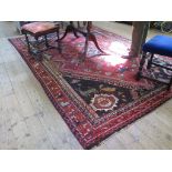 A Persian Kashqai design carpet with red field and blue spandrels filled with stylised birds and
