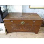 A Far Eastern camphorwood chest, carved with tree and houses 101cm wide, 50cm deep, 55cm high