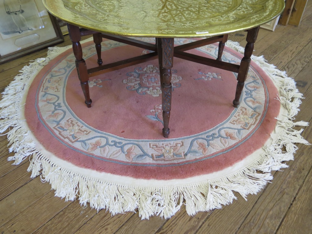 A Chinese pink circular rug, with floral designs 155cm diameter