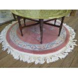 A Chinese pink circular rug, with floral designs 155cm diameter