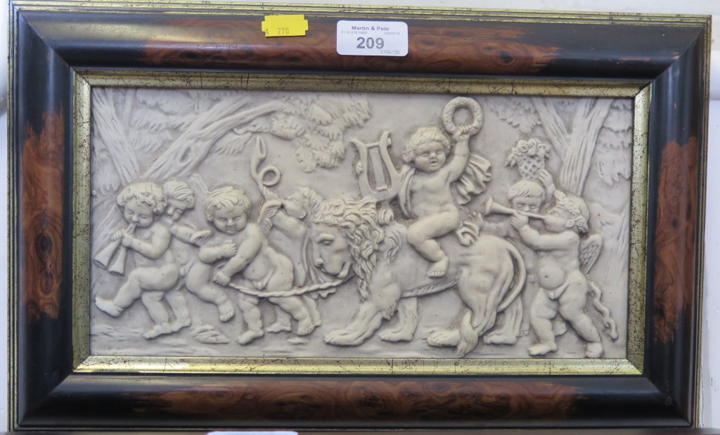 A framed plaque, depicting putti with instruments and a lion, 16 x 31cm