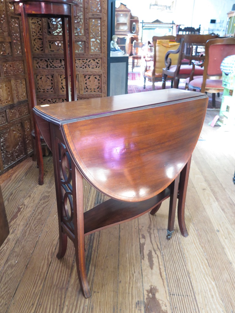 A mahogany and satinwood crossbanded Sutherland table, the oval top over fret carved supports on