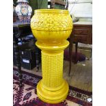 A Burmantofts yellow faience jardiniere and stand, the bulbous floral design jardiniere on a