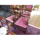 A matched pair of mahogany Willian IV carver dining chairs, each with broad top rails, scroll carved