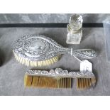 A ladies silver brush and comb, as found, and a small glass scent bottle with a silver collar