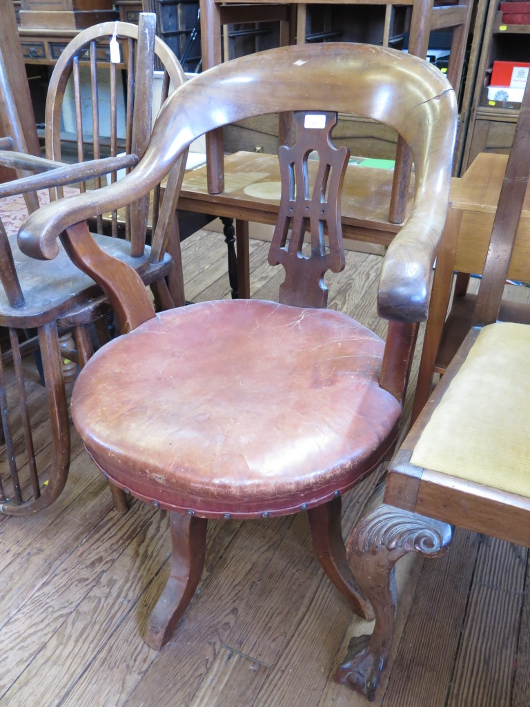 A 1920s walnut swivel office chair, with pierced splat and leather seat and two hoop back turned