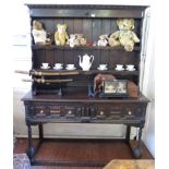 A late 17th century oak dresser and rack, the stepped two tier rack with later parts, over a dresser