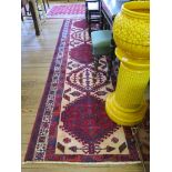 A Persian Heriz runner, the red and ivory medallions on an ivory field with a multiple border