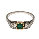 A platinum ring set with central emerald and two diamonds