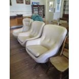 A pair of 1960s cream leatherette lounge chairs, on chromed swivel base, and another similar chair