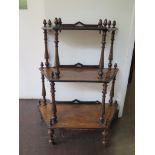 A Victorian crossbanded walnut and boxwood lined graduated whatnot with acorn finials and turned